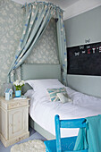 Einzelbett mit Baldachin und Kreidetafel im Mädchenzimmer Bishops Sutton Familienhaus Alresford Hampshire England UK