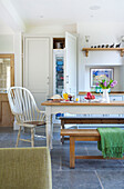 Gestrichener weißer Stuhl am Tisch in der offenen Küche des Hauses in Woodchurch, Kent, England, UK