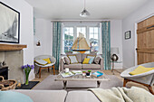 Cane chairs and sofa with model boat in window of Dartmouth living room Devon UK