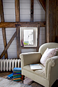 Sessel am original verriegelten Fenster in einer denkmalgeschützten Windmühle in Kent, Großbritannien