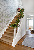 Beech wallpaper with garland on banister in staircase of Warehorne rectory Kent UK