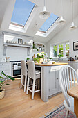 Pale grey open plan kitchen diner with three skylights and pendant lights Oxfordshire UK