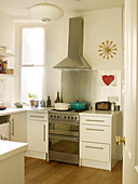 Auflaufform auf dem Kochfeld eines Edelstahlofens mit Dunstabzugshaube in der Küche eines Hauses in London England UK