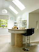 Black leather bar stools at breakfast bar with kitchen skylights in Nottinghamshire home England UK