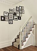 Black and white photograph collection in staircase of North London townhouse England UK