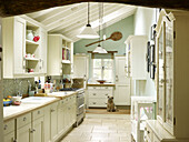 White fitted kitchen with wall mounted shelving in Nottinghamshire home England UK