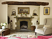 Armchair at fireplace in living room of Nottinghamshire home England UK