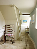 Wooden rocking chair in tiled staircase hallway of Nottinghamshire home England UK