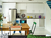 Upright fridge in open plan kitchen of London family home, UK