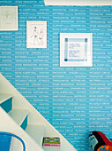 Gerahmte Drucke auf hellblauer Treppentapete in einem Einfamilienhaus in London, UK