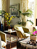 Gold armchair and plants with side table in London townhouse apartment, UK