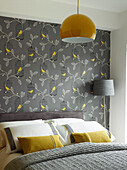 Graues und gelbes Schlafzimmer mit Vogel- und Blattmustertapete in einem Haus in Manchester, England, Vereinigtes Königreich