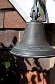 Antike Glocke hängt vor einem Landhaus in Kent, England, UK