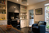 Wall clock and armchair in kitchen of London home UK