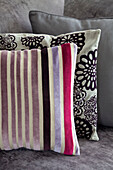 Assorted cushions on contrasting patterns in contemporary London home, England, UK