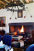 Blue tartan dining chairs in Scottish dining room with lit fire UK