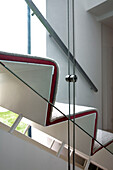 View through glass panelling to carpeted staircase in London home, England, UK