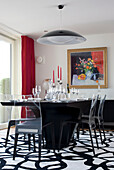 Transparent chairs on patterned rug in dining room of Newmarket home Suffolk UK