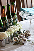 Weiße Rosen und Champagnerflaschen auf dem Tisch eines Hauses in den Cotswolds UK