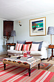 Patterned ottoman and striped floor rug in living room of East Sussex home, England, UK