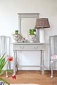 Rattan lamp on grey painted side table with mirror Sussex home detail UK