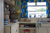 Kitchen detail with blue and yellow floral curtains in Rye home, East Sussex, England, UK