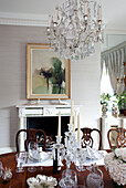 Glass chandelier and artwork in dining room of contemporary London townhouse, England, UK