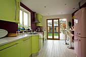 Lindgrüne Einbauküche im Retrostil mit lackierten Dielen in einem Haus in East Sussex, England, Vereinigtes Königreich