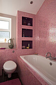 Rosa gefliestes Badezimmer in einem Haus im Retrostil in East Sussex, England, Vereinigtes Königreich