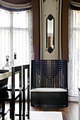 Narrow mirror above latticed wooden chair in dining room in contemporary London townhouse, England, UK