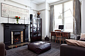 Großer Kamin im modernen Wohnzimmer eines Hauses in Hove mit Schreibtisch am Fenster, East Sussex, England, UK