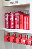 Rote Vorratsdosen und Tassen in einer Nische in einem Londoner Stadthaus, England, Vereinigtes Königreich
