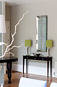 Rectangular mirror and matching lamps with wooden console in classic London home, UK