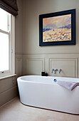 Zeitgenössische weiße Keramikbadewanne mit Sprossenfenster im getäfelten Badezimmer eines klassischen Londoner Hauses, UK