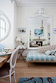 Light blue tartan blanket on chaise longue with large mirror in living room of contemporary London home, UK