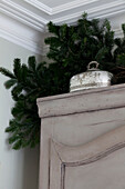 Silver butter dish and branch of pine on cupboard top in London townhouse, England, UK
