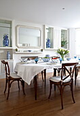 Wooden dining table and chairs in contemporary London townhouse, England, UK