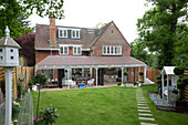 View of back of house with landscaped garden showing extension and veranda into open plan living space