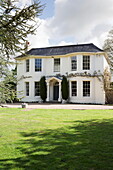 Lawn with gravel driveway to exterior of Sussex country home England UK