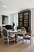 Glasvitrine mit Esstisch und Stühlen aus Marmor in einem historischen Landhaus in Sussex, England, UK