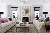 Zwei weiße Sofas mit Kissen im Wohnzimmer eines modernen Landhauses in Surrey England UK