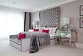 Pink and grey bedroom with silver metallic side table in contemporary Surrey country home England UK