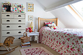 Bettdecke mit Rosenmuster unter der Dachgaube im Dachgeschoss in einem Cottage in Dorset, England, Vereinigtes Königreich