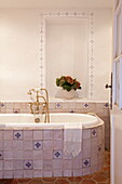Geflieste Badewanne mit Messing-Duscharmatur in einer Wohnung in Mougins, Alpes-Maritime, Südfrankreich