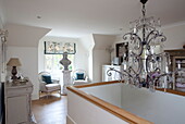 Cut glass chandelier above stairwell with seating in Kent home, England, UK