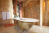 Freistehende Badewanne mit Fresken und Fensterstoffen in einer französischen Ferienvilla