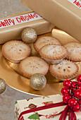Mince pies with baubles and Christmas gifts in West Sussex home, England, UK