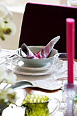 Place setting with napkin on dining table in London home England UK