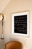 Sunhat and croquet mallet with blackboard and armchair in hallway of London home England UK