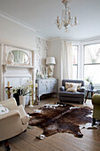Crean and grey armchairs with animal skin rug in living room of London townhouse, England, UK